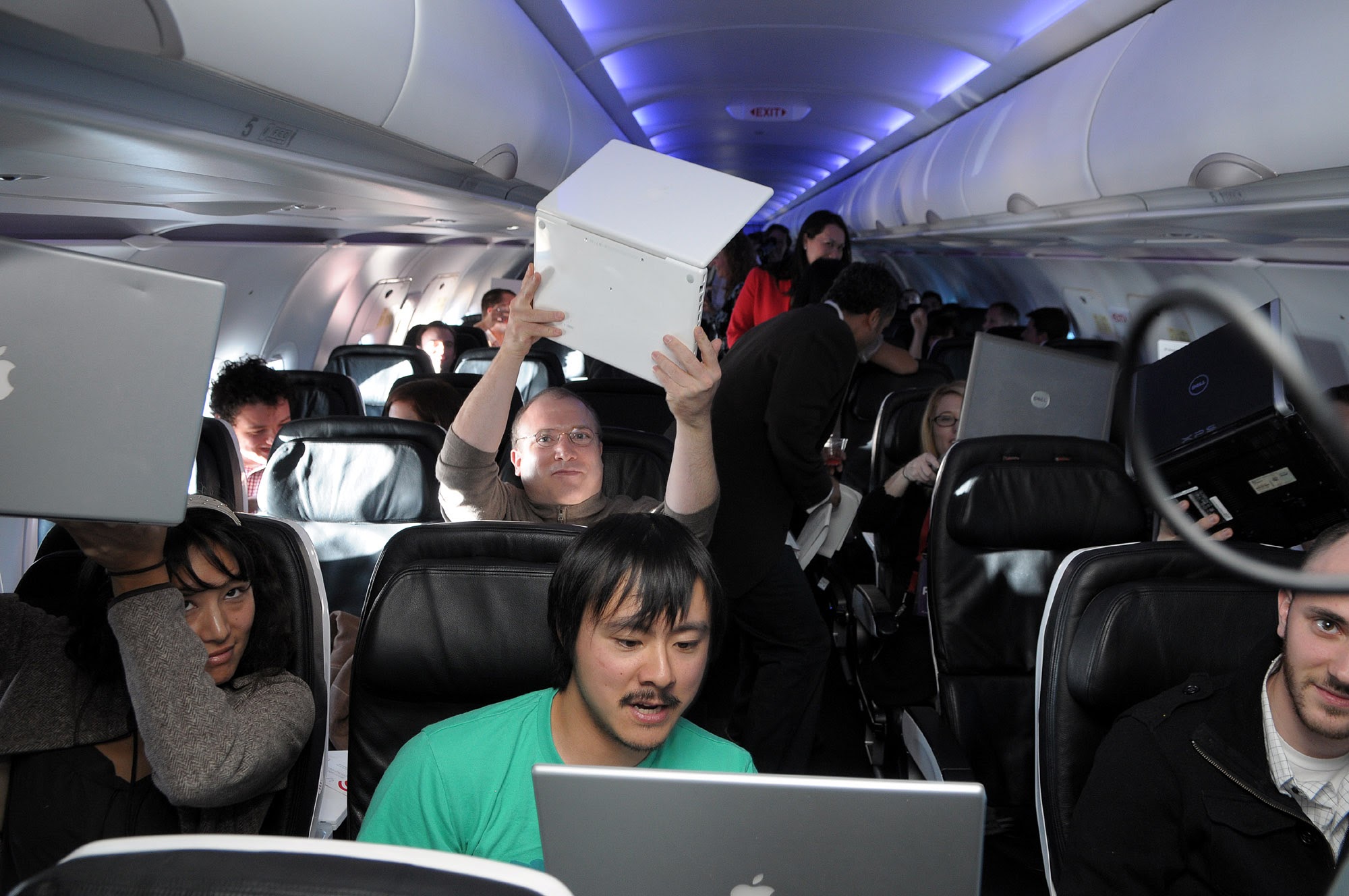  Me holding up a laptop on the inaugural Wi-Fi flight of Gogo service on Virgin America. That's Brian Lam and Ryan Block in the row ahead of me. 