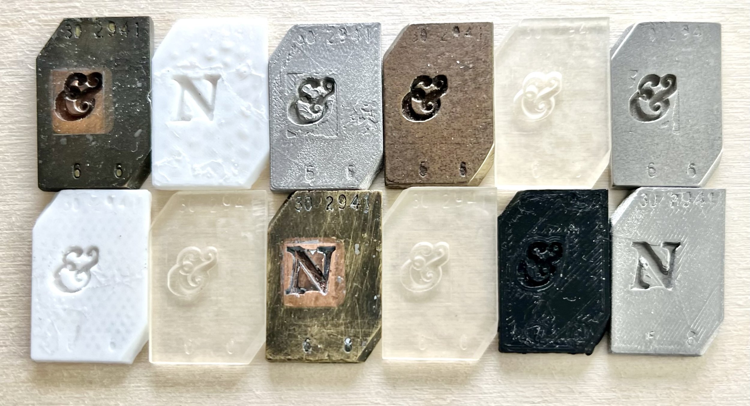 A variety of 3D prints of two originals—the originals have copper inset areas in their brass frames.