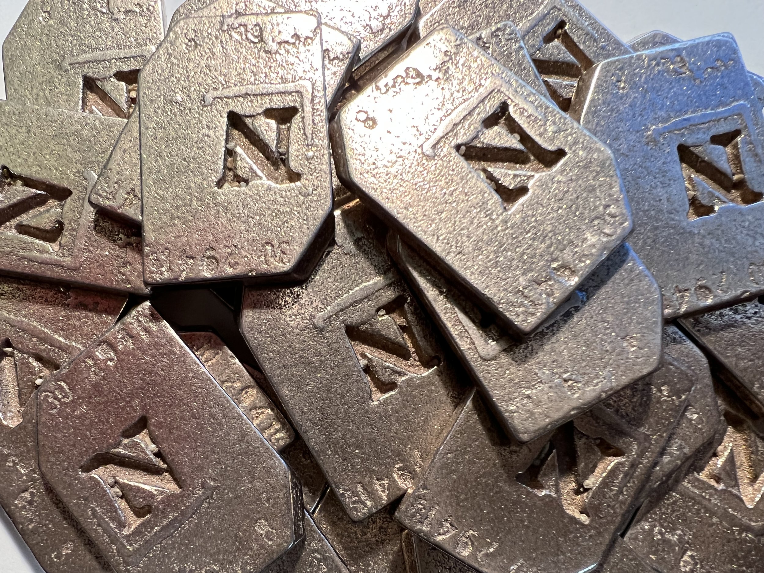  A pile of 3D printed Goudy Bold Italic N replica matrices 