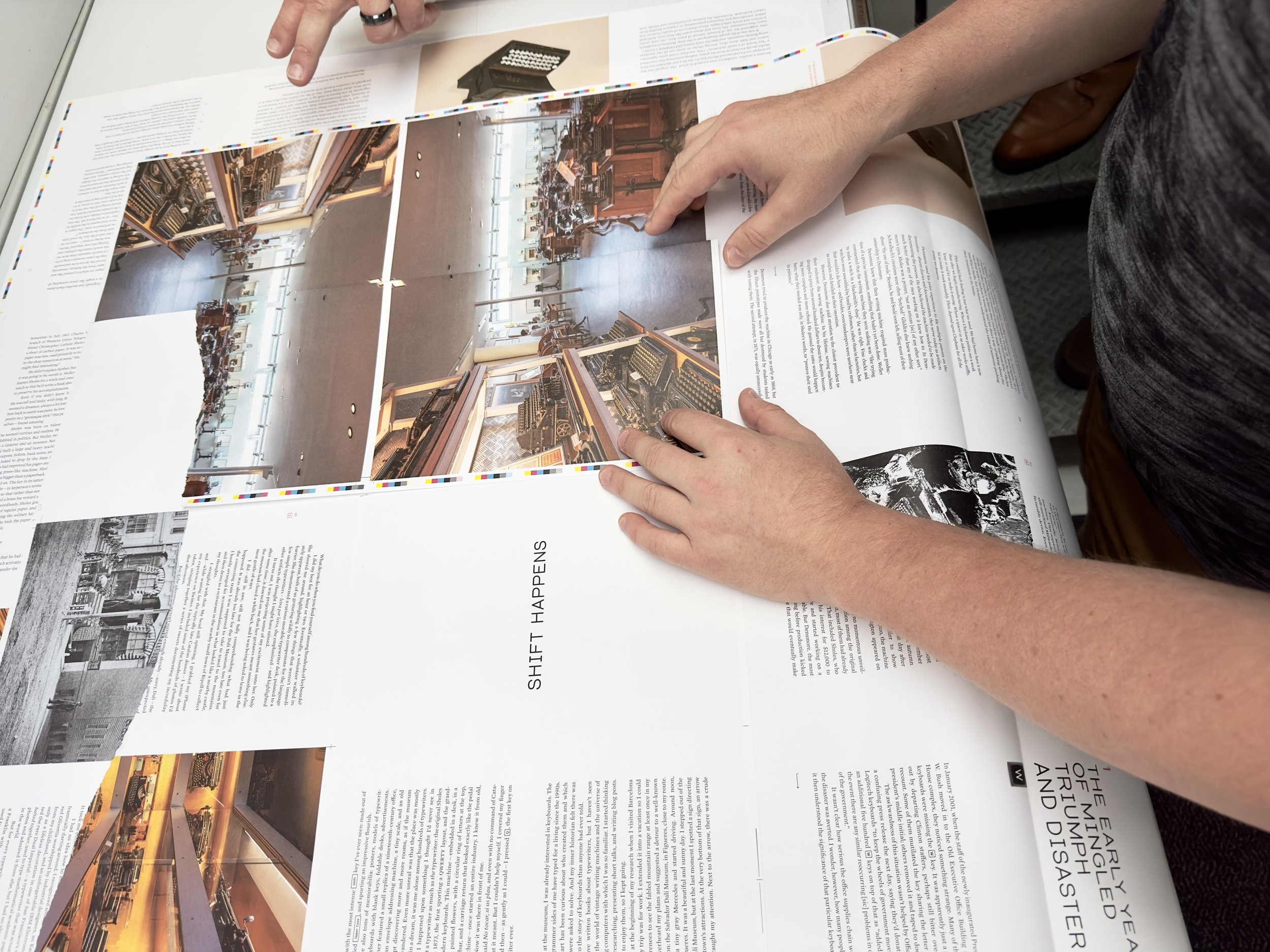 Hands on a hot copy: Marcin (right) and others examine a press sheet to check color.